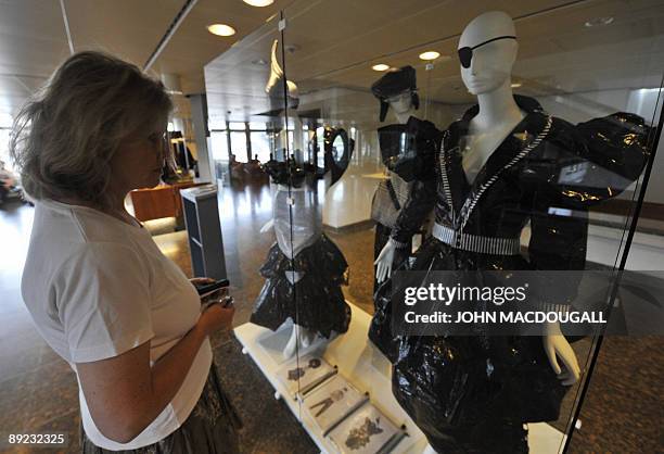 By Simon Sturdee A visitor looks at ensembles made of plastic film by east German fashion designer Sabine von Oettingen are on display at the...