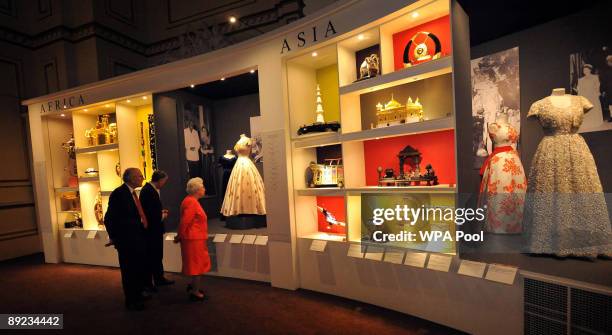 Queen Elizabeth II is shown around the Commonwealth exhibition at Buckingham Palace by Sir Hugh Roberts, Director of the Royal Collection on July 23,...