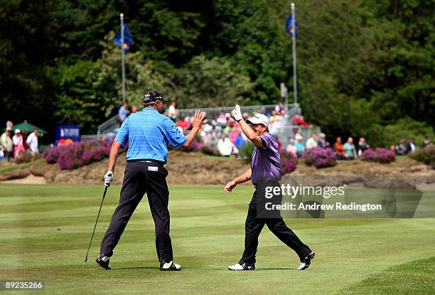 Fred Funk of the USA is congratulated by playing patner Mike Harwood of Australia after holing his second shot for an eagle on the 18th hole during...