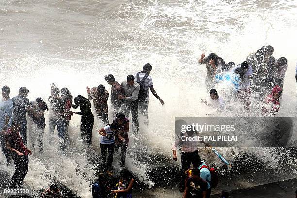 Onlookers and revellers throng the Marine Drive promenade on the Arabian Sea front as high tides lash its shores in Mumbai on July 24, 2009. The peak...