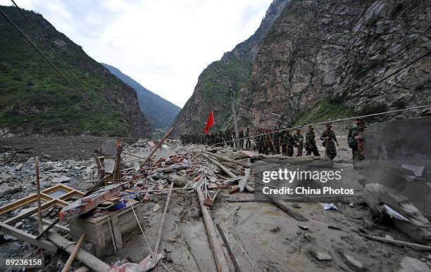 Paramilitary policemen walk to carry out rescue work after a landslide on July 24, 2009 in Kangding County of Ganzi Tibetan Autonomous Prefecture,...