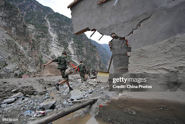 Paramilitary policemen walk to carry out rescue work after a landslide on July 24, 2009 in Kangding County of Ganzi Tibetan Autonomous Prefecture,...