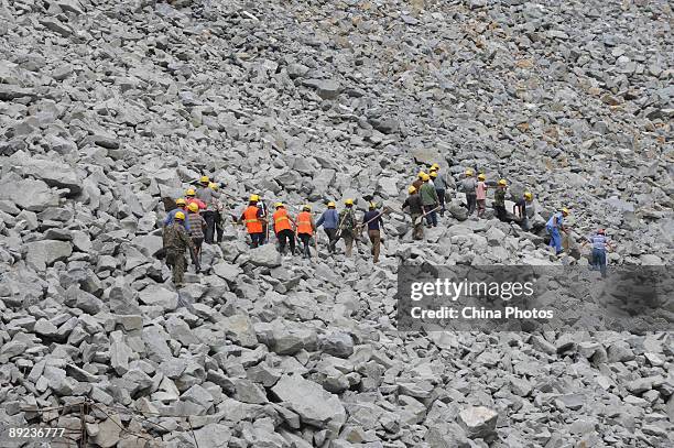 Members of a rescue team walk to carry out a mission after a landslide on July 24, 2009 in Kangding County of Ganzi Tibetan Autonomous Prefecture,...