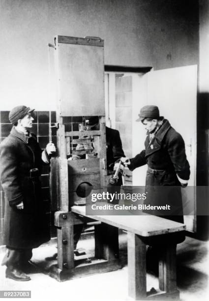 Russian troops with a guillotine or 'Tegel fallbeil' in the Death Chamber at Poznan, 1945.