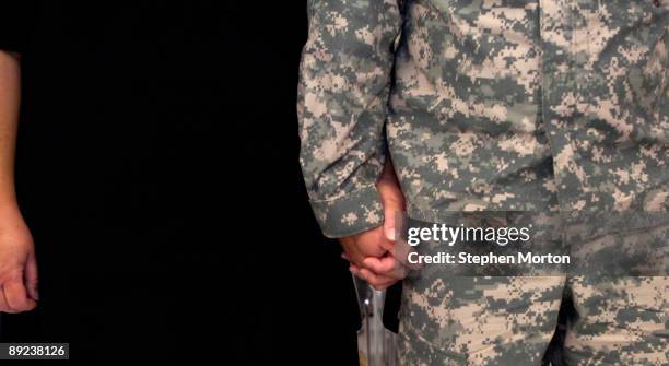 Soldier with the U.S. Army's 293rd Military Police Company holds hands with his wife during the 3rd Infantry Division's first Coin Covenant Ceremony...