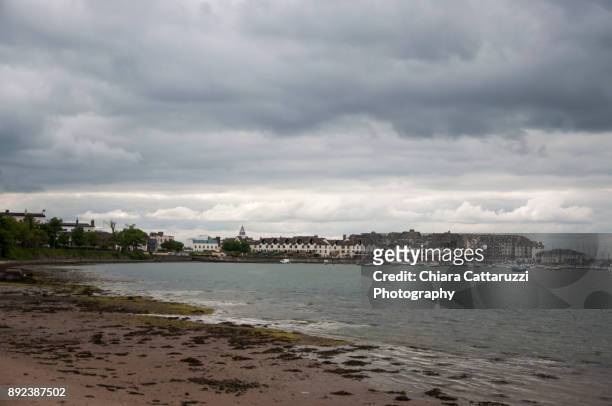 irish village and its sandy beach in a cloudy landscape - malahide stock pictures, royalty-free photos & images