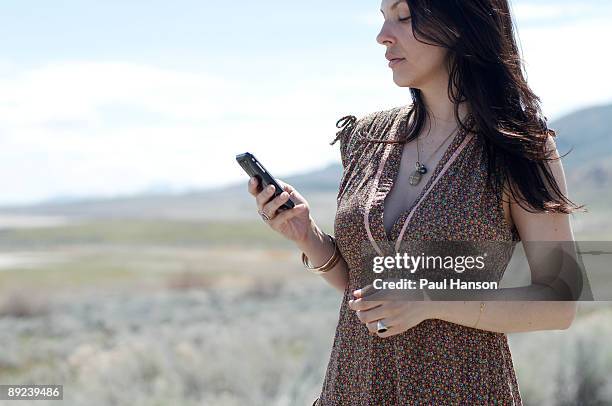 woman holding cell phone outdoors - ilha de antelope imagens e fotografias de stock