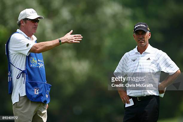 Corey Pavin discusses his shot with his caddie on the ninth fairway during round two of the RBC Canadian Open at Glen Abbey Golf Club on July 24,...