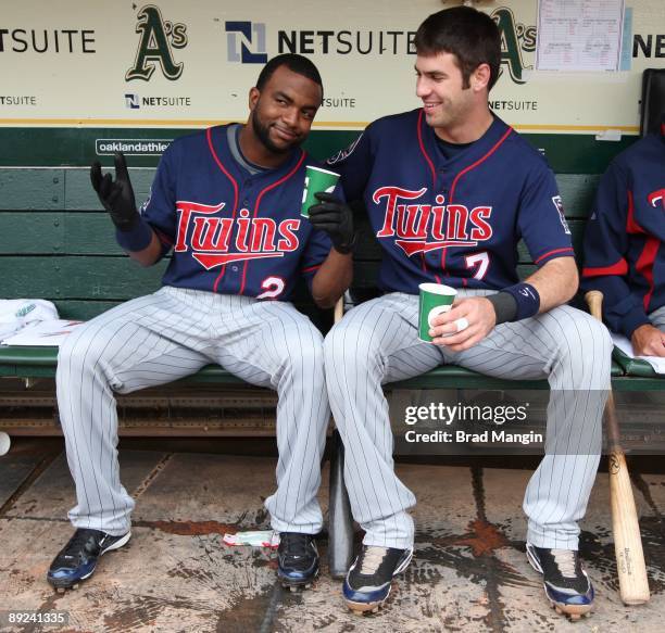 Joe Mauer and Denard Span of the Minnesota Twins get ready in the dugout before the game against the Oakland Athletics at the Oakland-Alameda County...