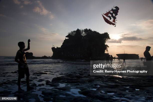boy flying kite at sunset - indonesian kite stock pictures, royalty-free photos & images