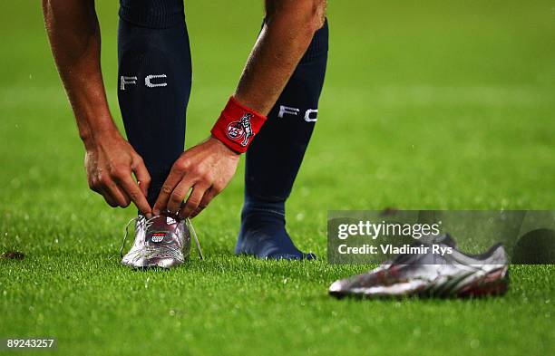 Lukas Podolski of Koeln takes off his shoes after the pre-season friendly match between 1. FC Koeln and FC Bayern Muenchen at RheinEnergie Stadium on...