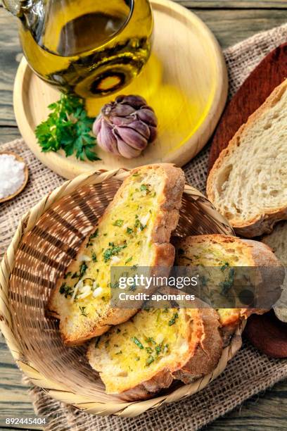snack or appetizer of garlic basil and olive oil bruschettas in basket. - garlic bread stock pictures, royalty-free photos & images