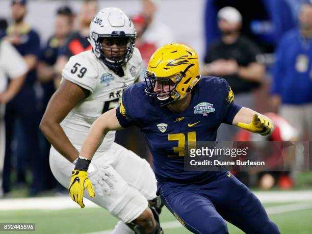 Defensive end Zach Quinn of the Toledo Rockets leaves offensive lineman Trevor Brown of the Akron Zips behind against during the second half at Ford...