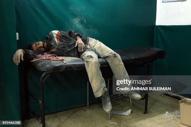 Syrian man awaits treatment at a makeshift hospital in Zamalka, near Syria's capital Damascus, on December 14 following reported shelling.