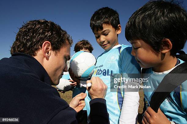 Adam Casey of Sydney FC signs autographs during the Optus Small Sided Football program announcment between Football Federation Australia and Optus at...