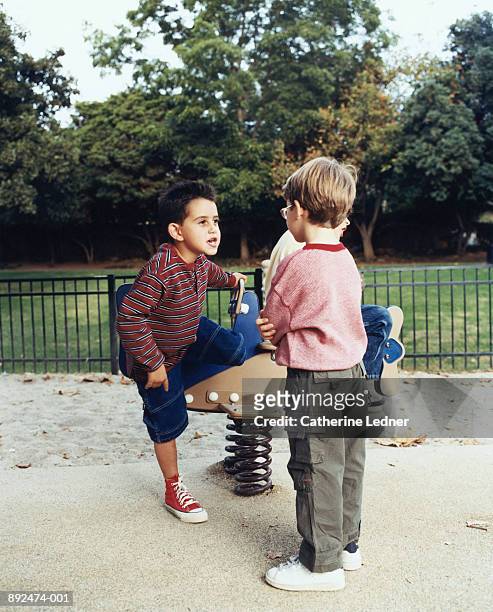 two boys (4-6) fighting over playground ride - children fighting stock pictures, royalty-free photos & images