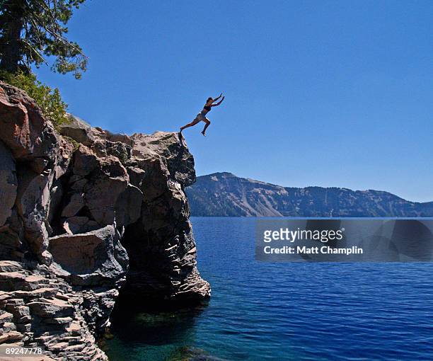 into the blue of crater lake - cliff dive stock pictures, royalty-free photos & images