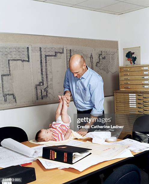 businessman changing daughter's diaper on conference room table - ohne zusammenhang stock-fotos und bilder