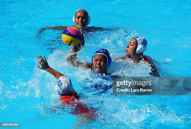 Natalya Plyusova of Uzbekistan is surrounded by Kazakhstan defenders as they compete in the Women's Water Polo Semifinals between Uzbekistan and...