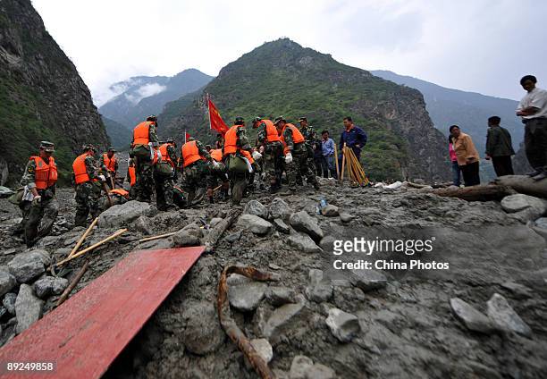 Paramilitary policemen carry out rescue work after a landslide on July 25, 2009 in Kangding County of Ganzi Tibetan Autonomous Prefecture, Sichuan...