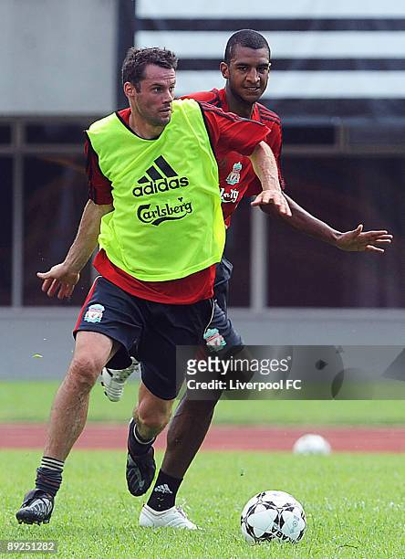 Liverpool's Jamie Carragher battles with David Ngog during a Liverpool training session at Singapore National Stadium on July 25, 2009 in Kallang,...