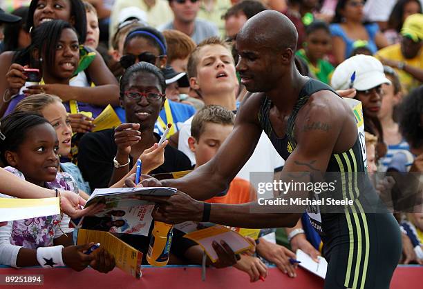 200m Sprinter Kim Collins of St. Kitts and Nevis signs autographs for the fans following his race during day two of the Aviva London Grand Prix track...