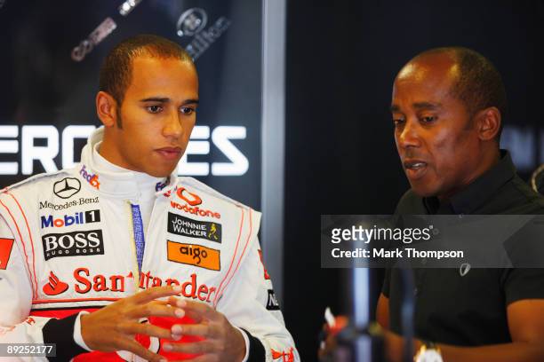 Lewis Hamilton of Great Britain and McLaren Mercedes talks to his father Anthony Hamilton as he prepares to drive during qualifying for the Hungarian...