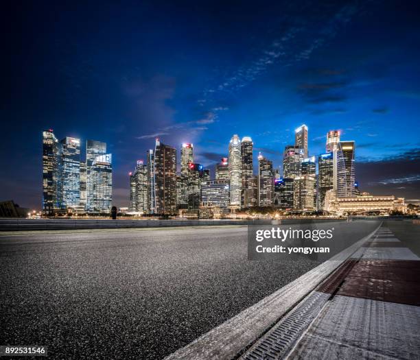 asfaltweg in singapore's nachts - stadsweg stockfoto's en -beelden