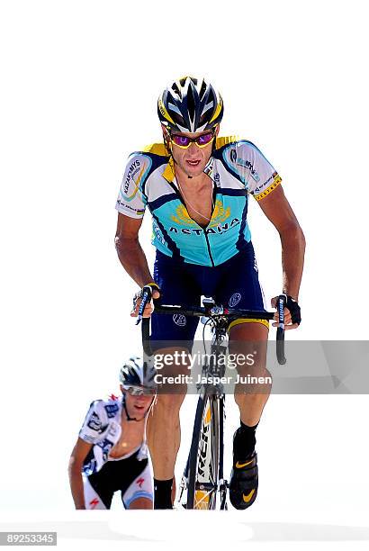 Lance Armstrong of USA and team Astana crosses the finishline backdropped by Frank Schleck of Luxembourg and team Saxo Bank at the end of stage 20...