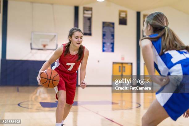 action-packed girl's high school basketball game - offense sporting position stock pictures, royalty-free photos & images