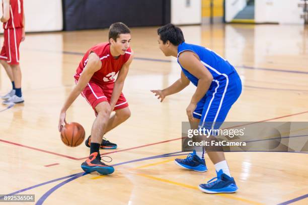 action-geladenen jungen high school basketballspiel - basketball teenager stock-fotos und bilder