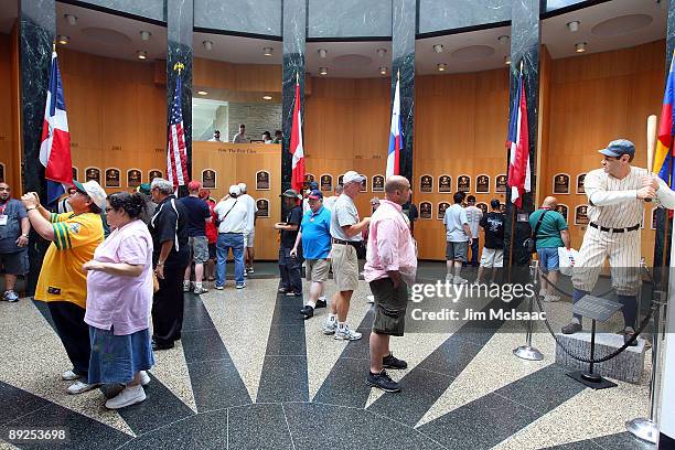 Baseball fans view the plaques of inducted players at the National Baseball Hall of Fame during induction weekend on July 25, 2009 in Cooperstown,...