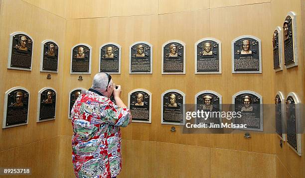 Baseball fan takes photographs of the plaques of inducted players at the National Baseball Hall of Fame during induction weekend on July 25, 2009 in...