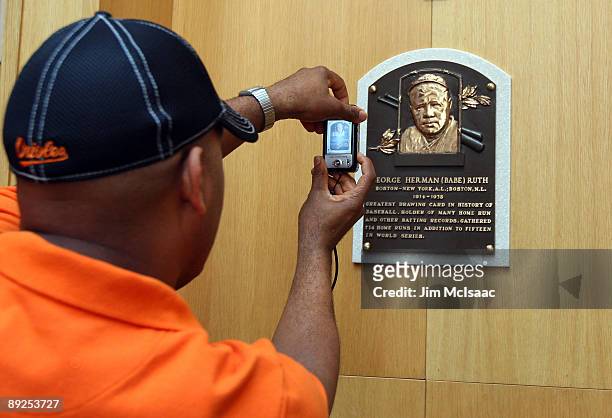 Baseball fan takes photograph of the plaque of Babe Ruth at the National Baseball Hall of Fame during induction weekend on July 25, 2009 in...