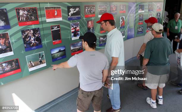 Baseball fans view photographs at the National Baseball Hall of Fame during induction weekend on July 25, 2009 in Cooperstown, New York.