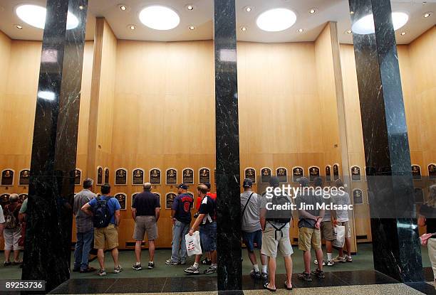 Baseball fans view the plaques of inducted players at the National Baseball Hall of Fame during induction weekend on July 25, 2009 in Cooperstown,...
