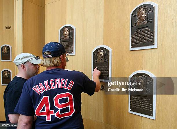 Baseball fans view the plaques of inducted players at the National Baseball Hall of Fame during induction weekend on July 25, 2009 in Cooperstown,...