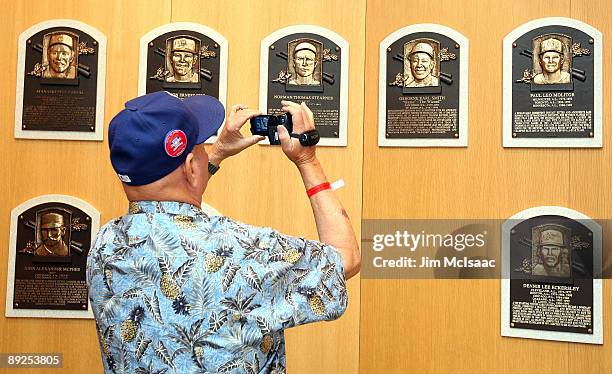 Baseball fan takes photographs of the plaques of inducted players at the National Baseball Hall of Fame during induction weekend on July 25, 2009 in...