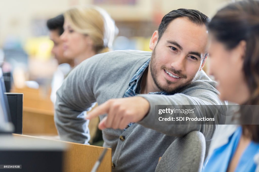 Männliche College-Student hilft Klassenkamerad im Computerraum