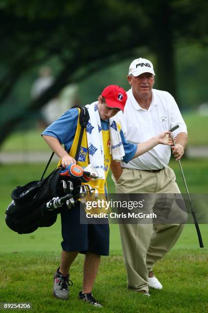 Mark Calcavecchia is handed his putter by son Eric Calcavecchia as they walk to the ninth green during round two of the RBC Canadian Open at Glen...