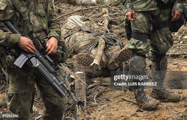 Colombian soldiers stand next to the body of a member of the Revolutionary Armed Forces of Colombia , in a rural zone in Puerto Rico, Meta...