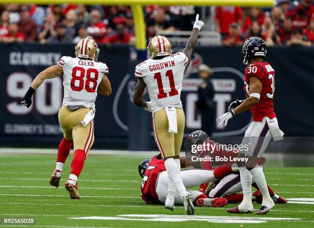 Garrett Celek of the San Francisco 49ers runs with the ball after a pass as Kareem Jackson of the Houston Texans and Andre Hal pursue at NRG Stadium...