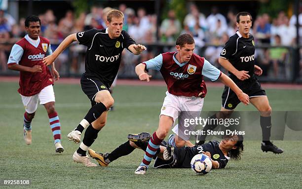 Chris McCann of Burnley moves the ball against Keith Savage and Tak Nishimura of the Portland Timbers during the first half of the match at PGE Park...