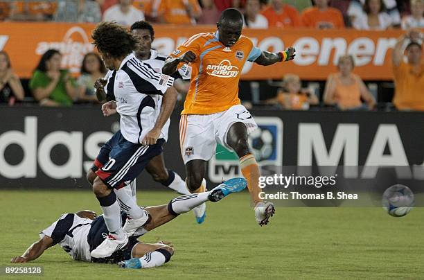 Dominic Oduro of the Houston Dynamo is defended by Kevin Alston of the New England Revolution at Robertson Stadium on July 25, 2009 in Houston, Texas.