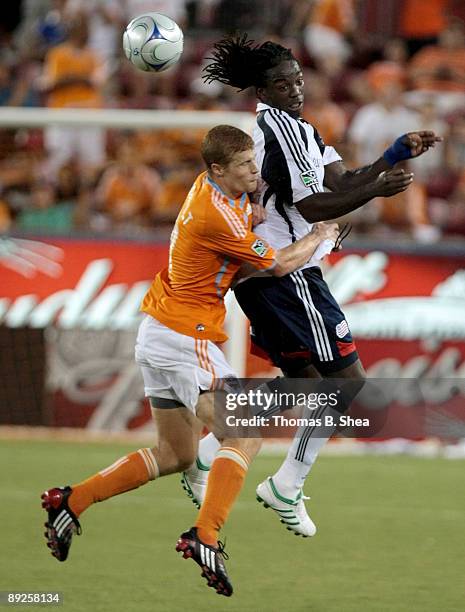 Andrew Hainault of the Houston Dynamo heads the ball against Shalrie Joseph of the New England Revolution at Robertson Stadium on July 25, 2009 in...