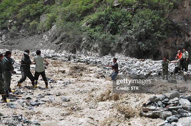 Chinese rescuers pull a survivor to safety after a rock slide in mountainous Kangding county, southwest China's Sichuan province on July 23 which...