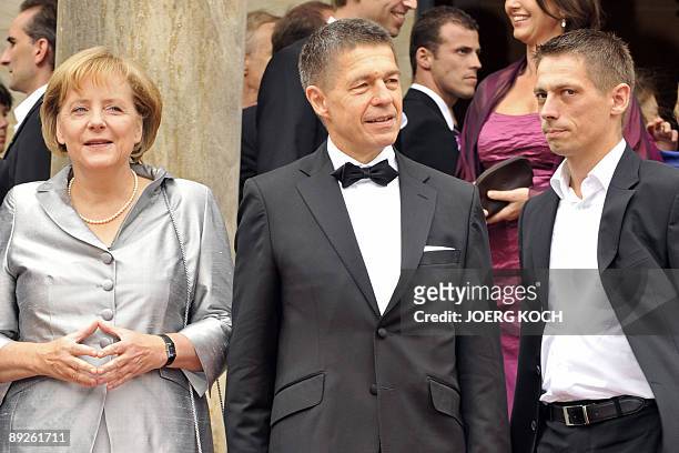 German Chancellor Angela Merkel, her husband Joachim Sauer and his sohn Daniel arrive on the red carpet in front of the "Festspielhaus" in the...