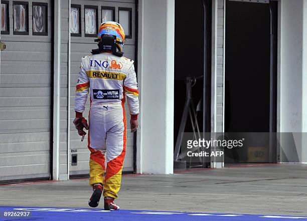 Renault's Spanish driver Fernando Alonso walks in the pits of the Hungaroring racetrack after he retired, on July 26, 2009 in Budapest, during the...