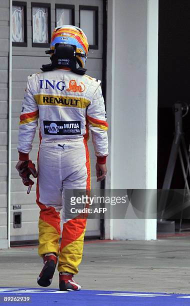 Renault's Spanish driver Fernando Alonso walks in the pits of the Hungaroring racetrack after he retired, on July 26, 2009 in Budapest, during the...