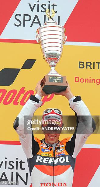 Andrea Dovizioso of Italy celebrates on the podium after winning the British Grand Prix at Donington Park, in Leicestershire, central England, on...